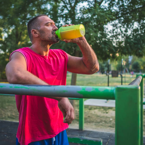 istock Muscular man drinking juice during street workout 1334689981