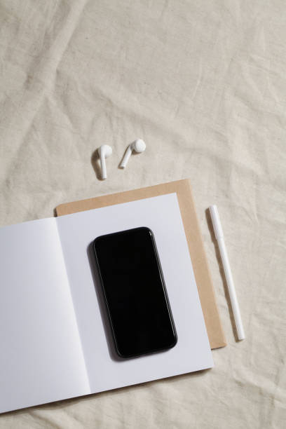 workplace with notebook, pen, phone and headphones on linen textile. Kinfolk designed. minimal, stylish concept. working table.