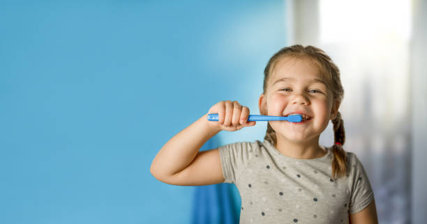 istock little girl brushing teeth in the bathroom 1334694259