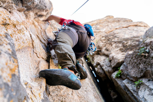 istock Athletic man climbing on overhanging cliff rock 1334695959