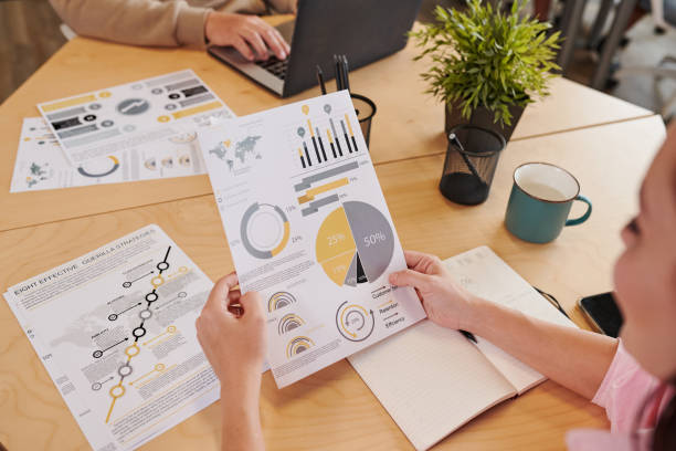 istock Close-up of unrecognizable woman analyzing statistical data while working with report in office 1334695990
