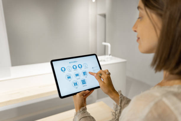 istock Woman controls smart kitchen appliances with mobile device 1334696298
