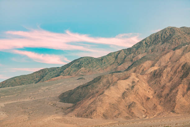 Beautiful pink and blue sunset behind dry rugged terrain in Death Valley desert