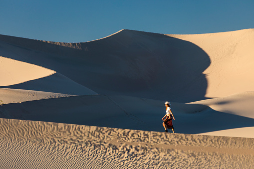 A person sitting on a sand dune at the Great Sand Dunes National Park in Colorado