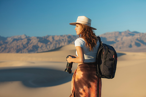 Female photographer exploring desert sand dunes in Death Valley national park