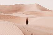 Portrait of woman standing holding camera in beautiful desert dunes