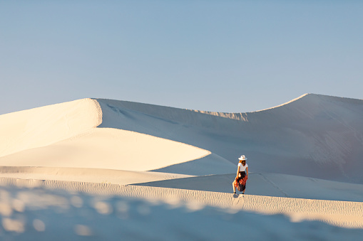 Woman standing in white desert sand dunes