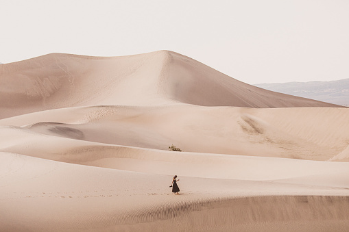 Woman walking playfully in desert sand dunes