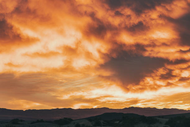 Firey orange and red sky over desert mountain range
