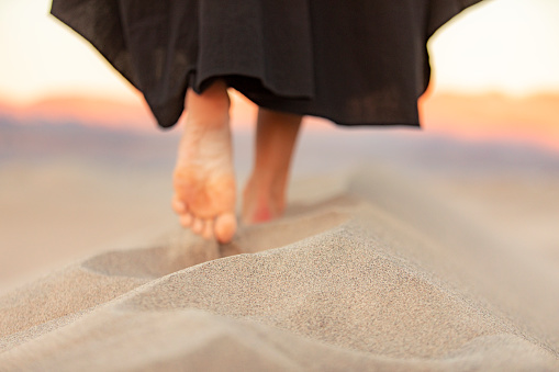 Closeup of male feet on the beach sand. Vacation concept.