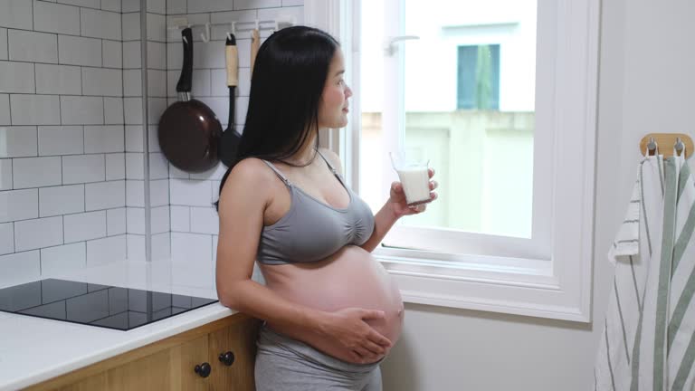 Pregnant woman drinking milk at home