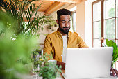istock Young man with laptop and coffee working indoors, home office concept. 1334702614