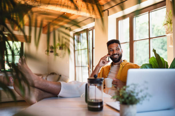 istock Young man with laptop and coffee working indoors, home office concept. 1334702903