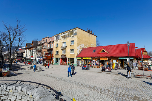 Zakopane, Poland - March 09, 2015: Krupowki street, the main shopping area and pedestrian promenade in the downtown. Zakopane, due to its attractive location in the immediate vicinity of the Tatra Mountains is a city that is often and willingly visited by tourists.