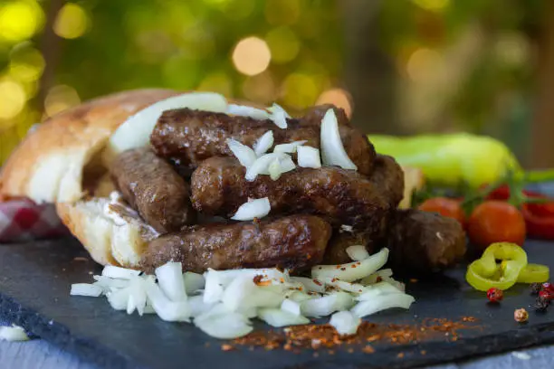 Grilled kebab, turkish style barbecued minced meat with onion. Traditional Balkan food - cevapi or cevapcici.