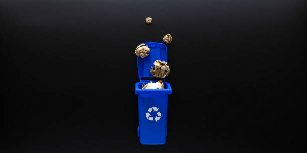 istock Precycling paper. Bin container for disposal garbage waste and save environment. Blue dustbin for recycle paper trash on black background. Flat lay. 1334707012