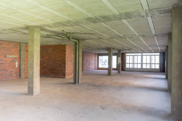 Wide-angle background image of an empty building under construction with concrete columns.