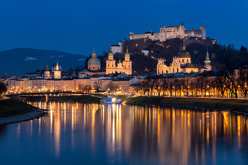 Salzburg, Austria - Wide angle view of Salzburg Skyline reflected in the Salzach River at dusk.