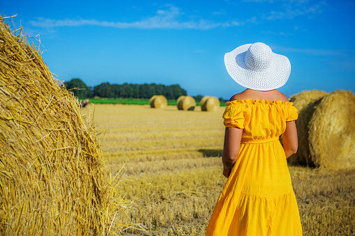 A beautiful mixed race woman enjoying some free time in a colourful field of harvested grain on a lovely summer's day