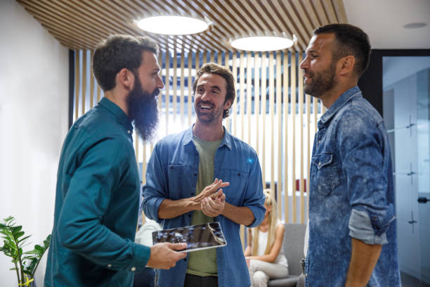 istock Three male colleagues standing in office lobby and chatting 1334718077
