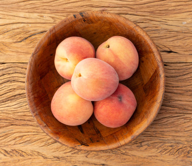istock Peaches on a bowl over wooden table 1334725420