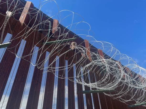 A glove caught on razor wire on the Border Wall Doors wide open on the southern border wall near Douglas, AZ. sonoran desert stock pictures, royalty-free photos & images