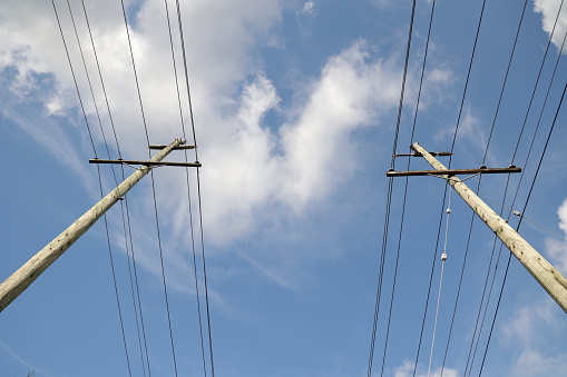 Rows of power lines extend on an electrical grid through Metro Vancouver. Summer morning with light cloud cover.