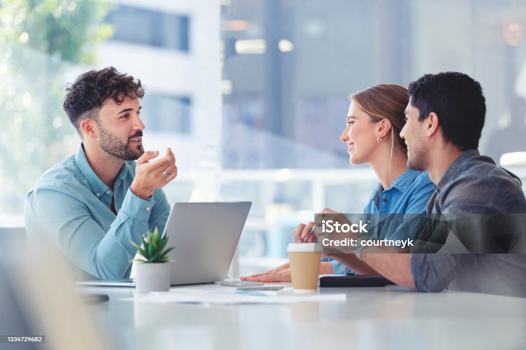 Financial advisor with couple explaining options Financial advisor with couple explaining options. The agent is using a computer. Couple are casually dressed. They sitting in an office and are discussing something with the agent. Financial Advisor Stock Photo