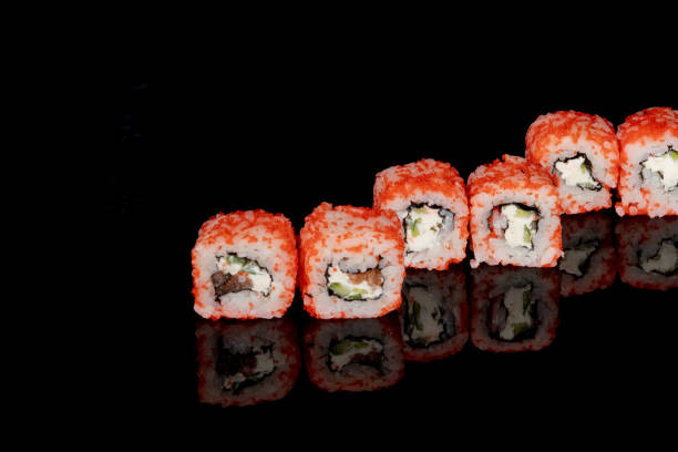 istock Philadelphia roll with salmon, cheese and cucumber on a black background with reflection. Sushi Philadelphia 1334729706