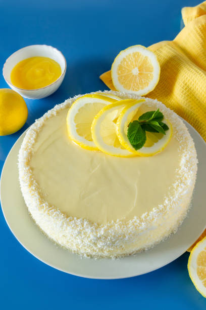 istock Lemon cake with coconut flakes on blue background. Delicate dessert with cream. 1334734015