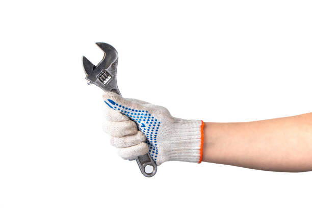 istock Man in white work gloves holds wrench. Happy labor day. Hand repair tool isolated on white background. 1334734037