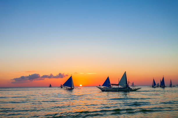 Traditional filipino boat at the idyllic white sand beach at Boracay island in Philiphines at sunset