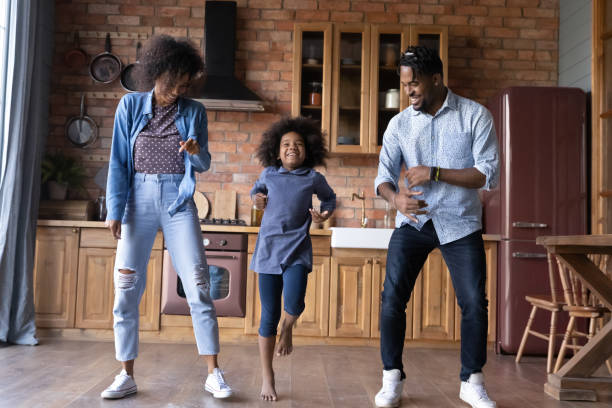 istock Excited ethnic family with kid dance together in kitchen 1334745249