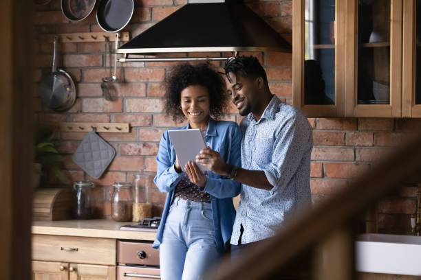 istock Happy biracial couple use tablet at home kitchen 1334745259