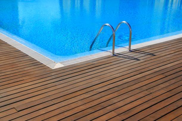 istock blue swimming pool with teak wood flooring 1334745897