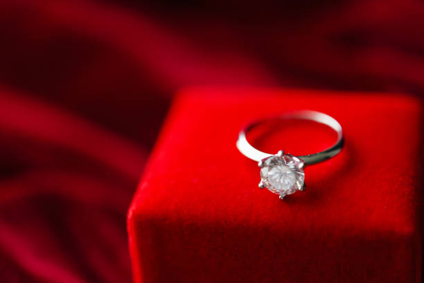 istock Diamond ring with jewelry gift box on red fabric background 1334748439