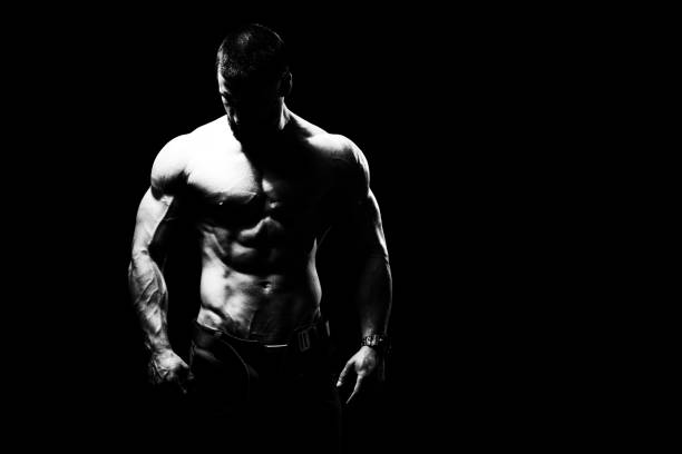 istock Muscular Man Flexing Muscles on Black Background 1334750214