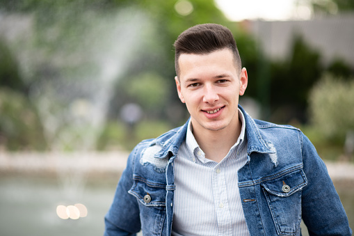 Portrait of a Confident and Successful Young Man With Blue Jacket Outside in Park