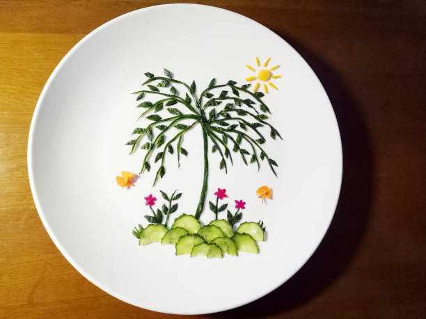 istock Close-up fruit platter art, cucumber, carrot on white dish, top view 1334755131