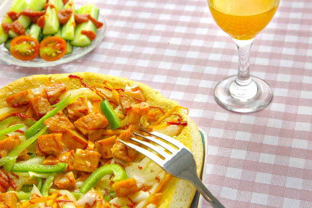 Close-up delicious pizza, juice, tomato, cucumber, sauce on gingham pattern background