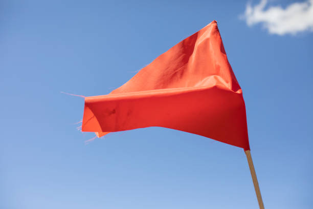 istock Red flag against the sky. Red matter on a stick. 1334756024