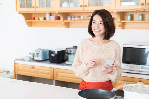 istock attractive asian woman to see a smart phone,kitchen 1334763237