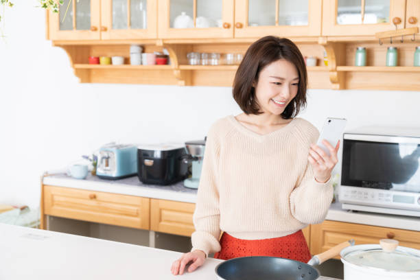 istock attractive asian woman to see a smart phone,kitchen 1334763258