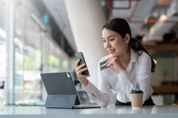 young asian businesswoman enjoy shopping online using credit card at a coffee shop. - digital tablet women enjoyment happiness imagens e fotografias de stock