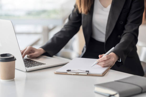 istock Young business woman take notes and using a laptop in the office. 1334764368