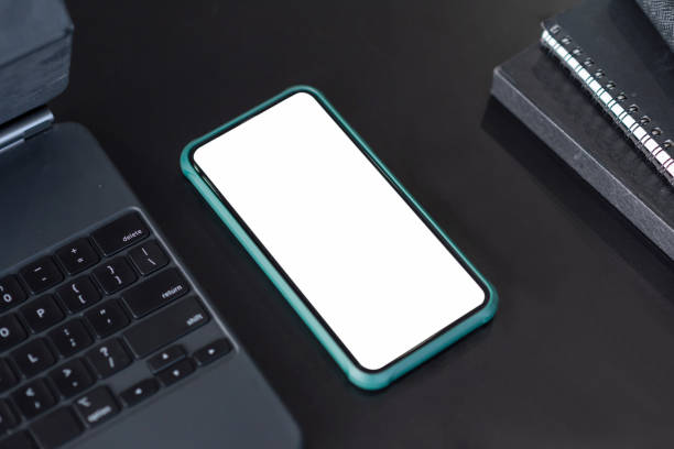 istock Mockup blank screen smartphone and equipment on black top table. 1334764947