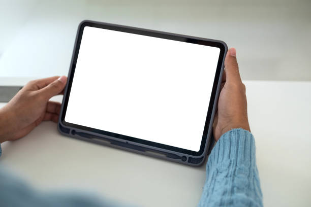 istock Mock up. Man holding tablet white blank screen at home. 1334766635