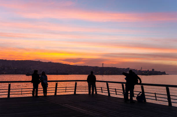 Silhouette of people enjoying the sunset on main pier of Valparaiso, Chile.