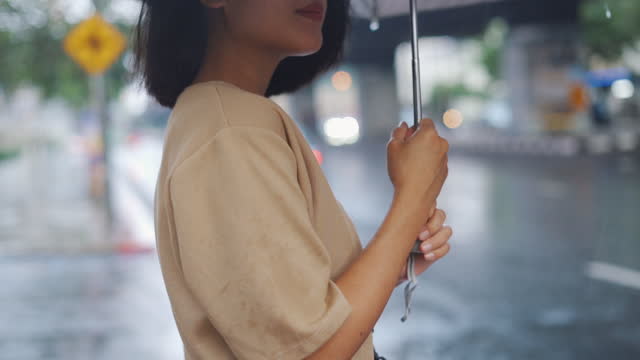 Slow motion of woman holding an umbrella in the rain