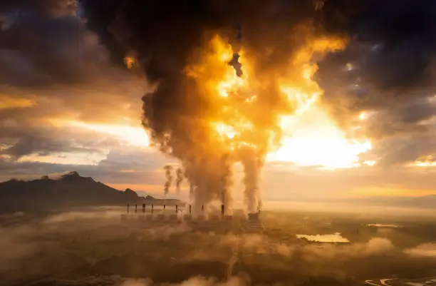 Aerial view coal power plant station in the morning mist, the morning sun rises. coal power plant and environment concept. Coal and steam. Mae Moh, Lampang, Thailand.